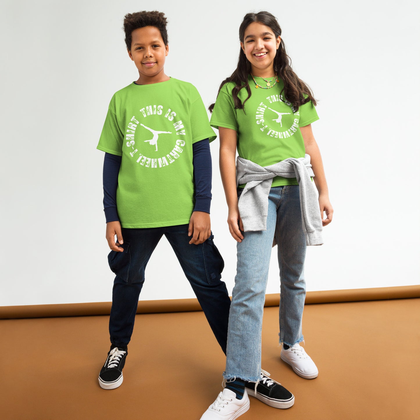 Kids gymnastics T-shirt outfit on two children; green tee with white gymnast logo