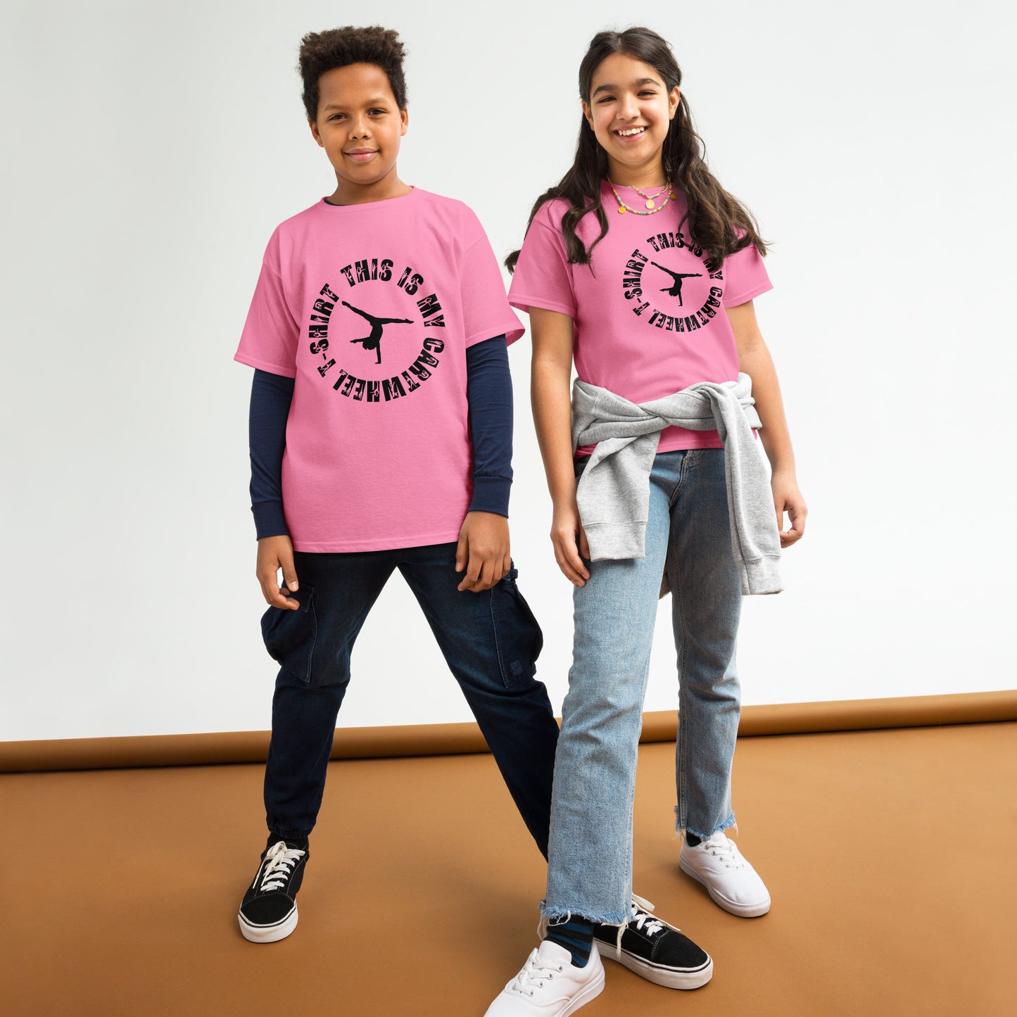 Kids gymnastics T-shirt in pink with black gymnast graphic at center chest.