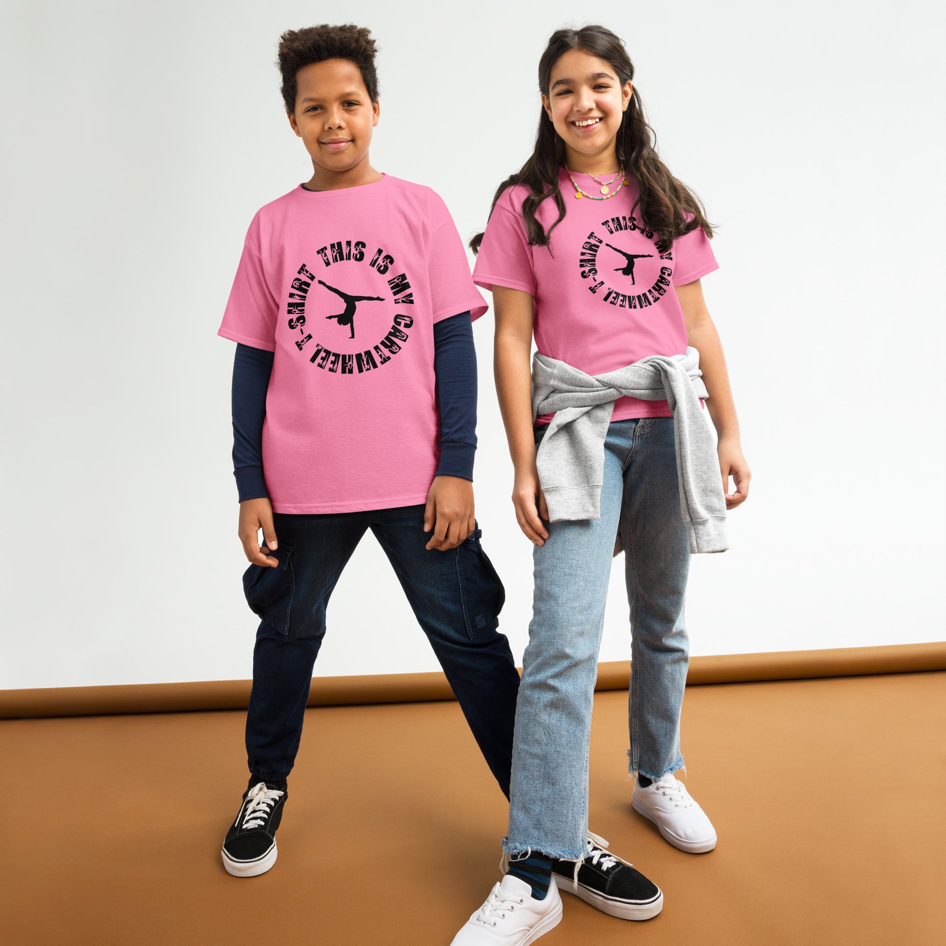 Kids gymnastics T-shirt in pink with black gymnast graphic at center chest.