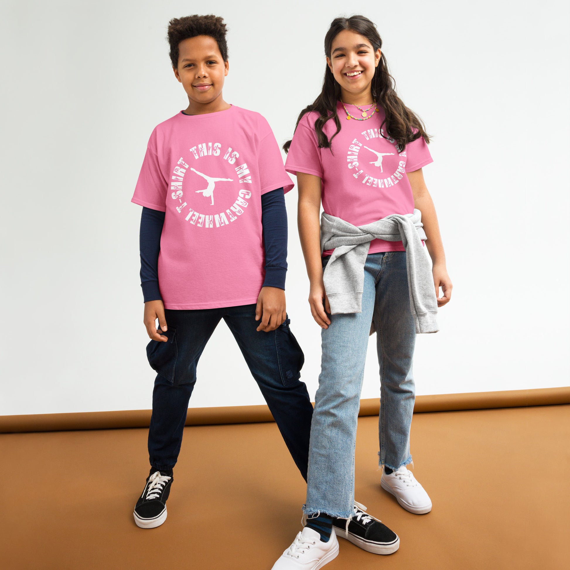 Kids gymnastics T-shirt outfit on two children; pink tee with white gymnast logo