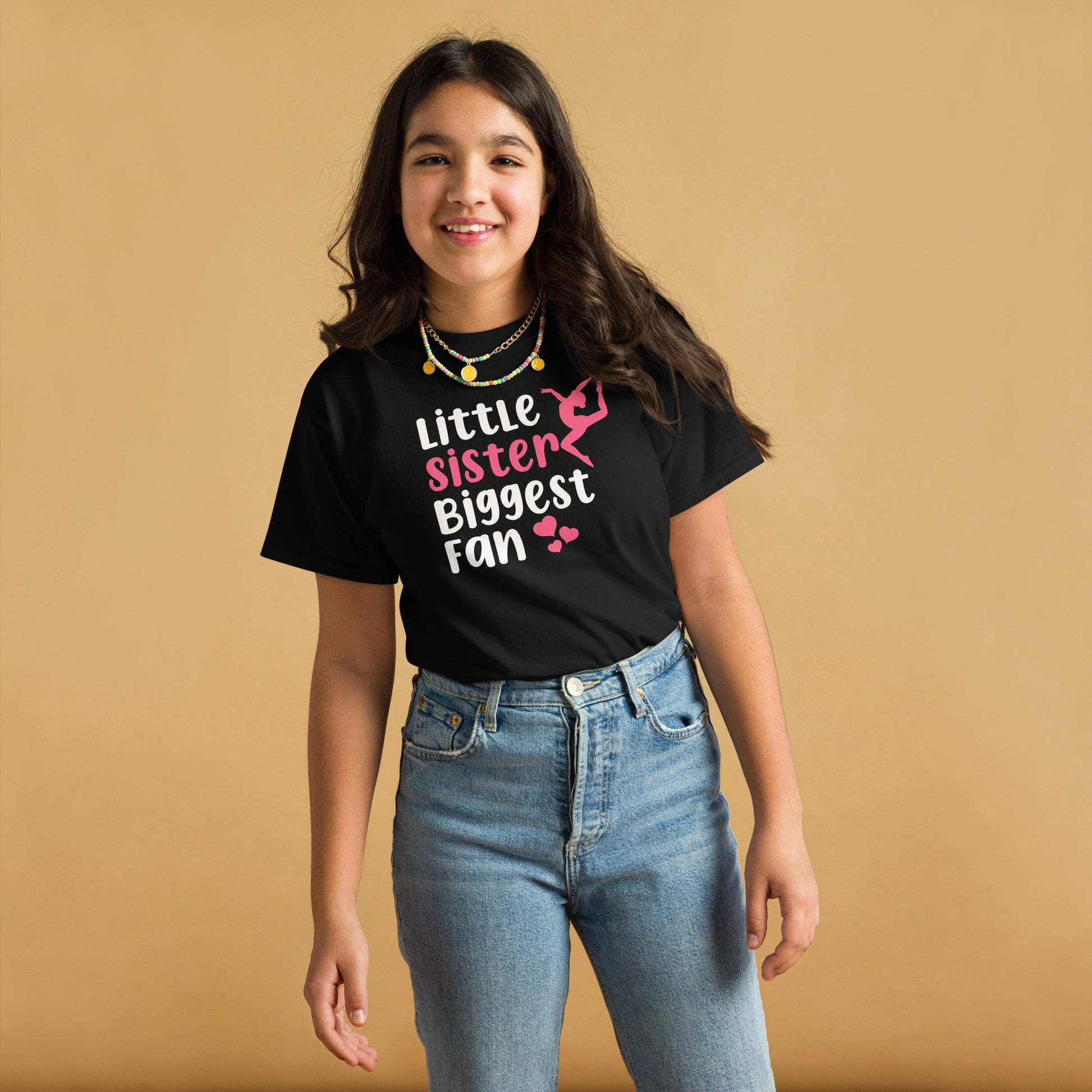 Youth black gymnastics T-shirt with pink gymnast silhouette and “Little Sister” slogan