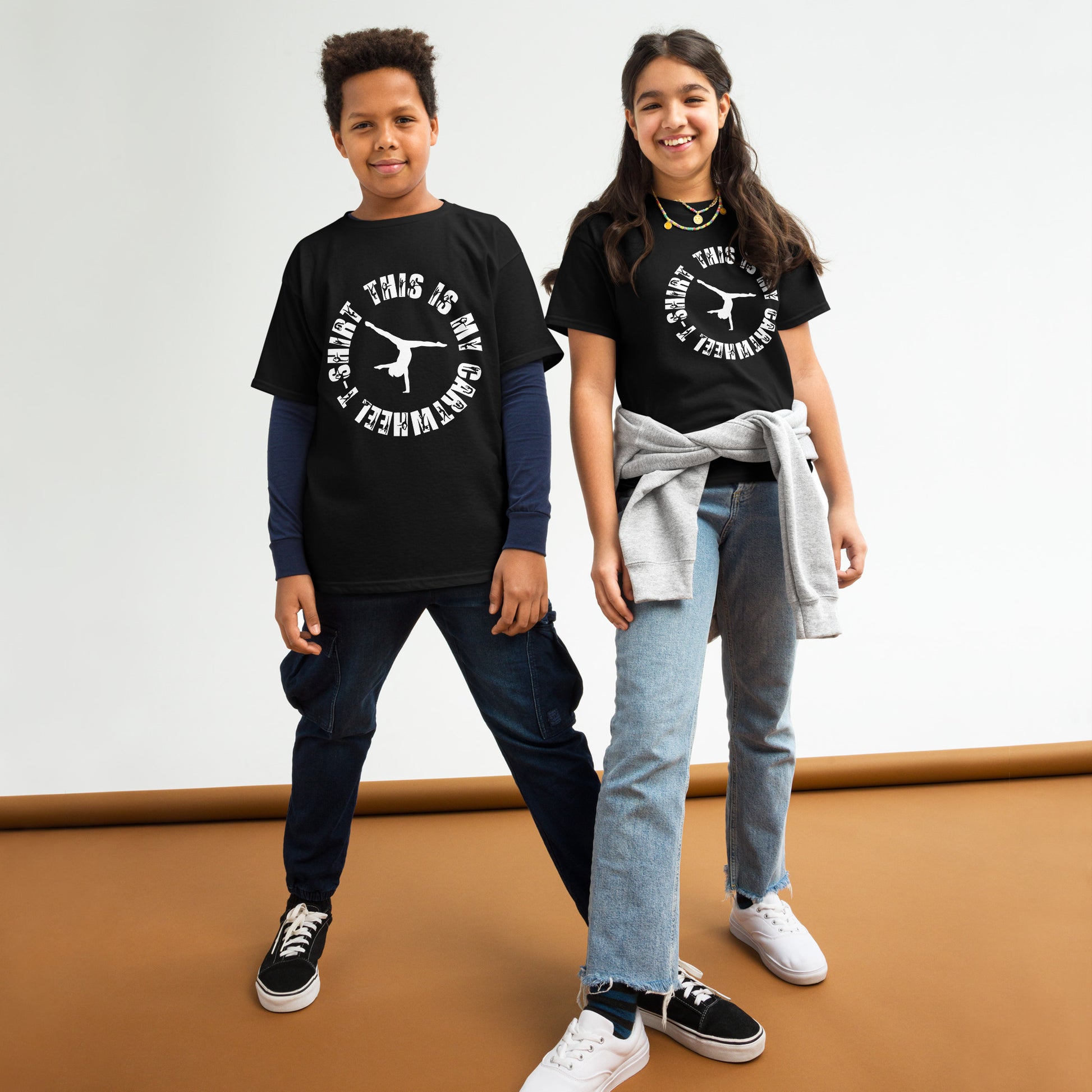 Kids gymnastics T-shirt outfit on two children; black tee with white gymnast logo