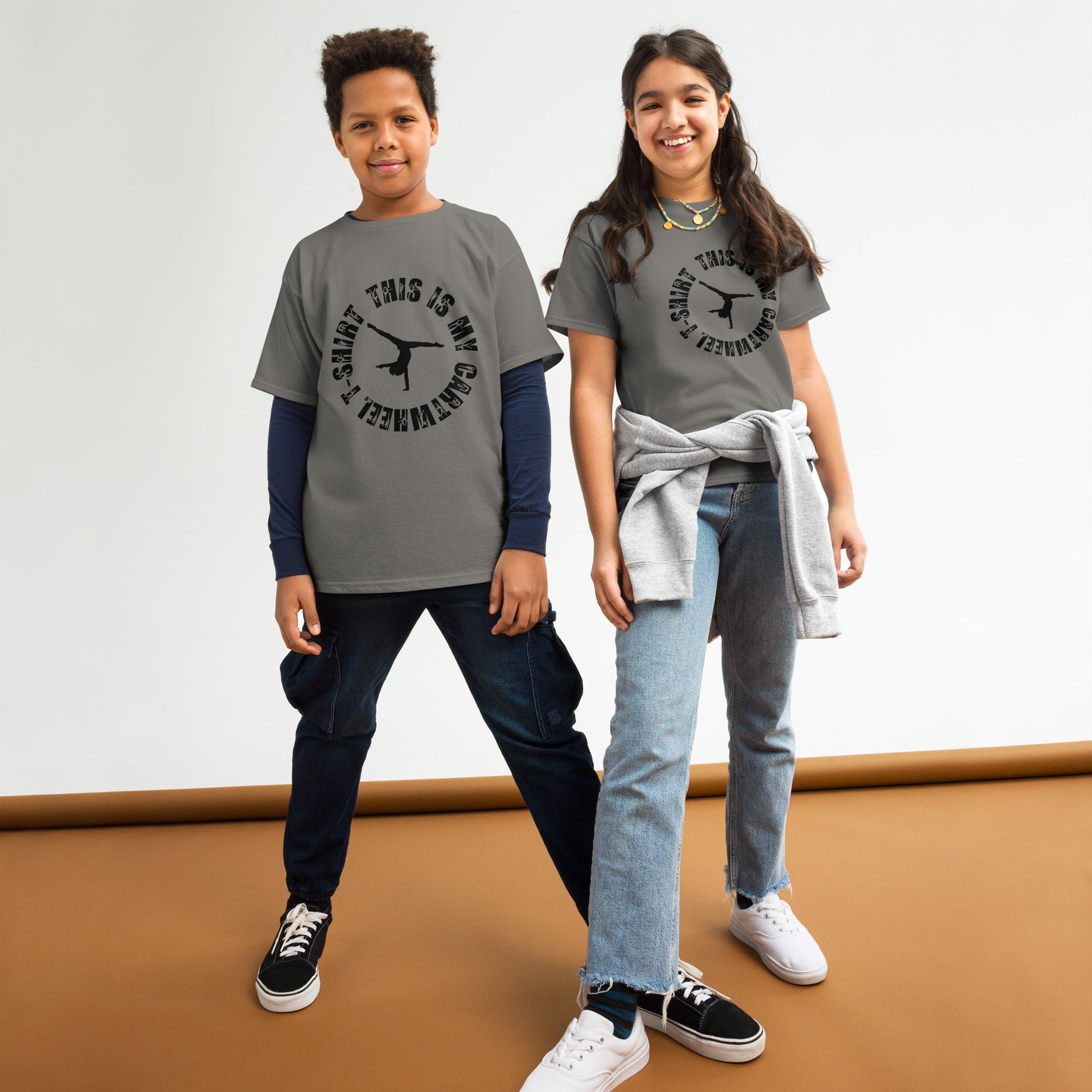 Kids gymnastics T-shirt in charcoal gray with black gymnast graphic and ring text.