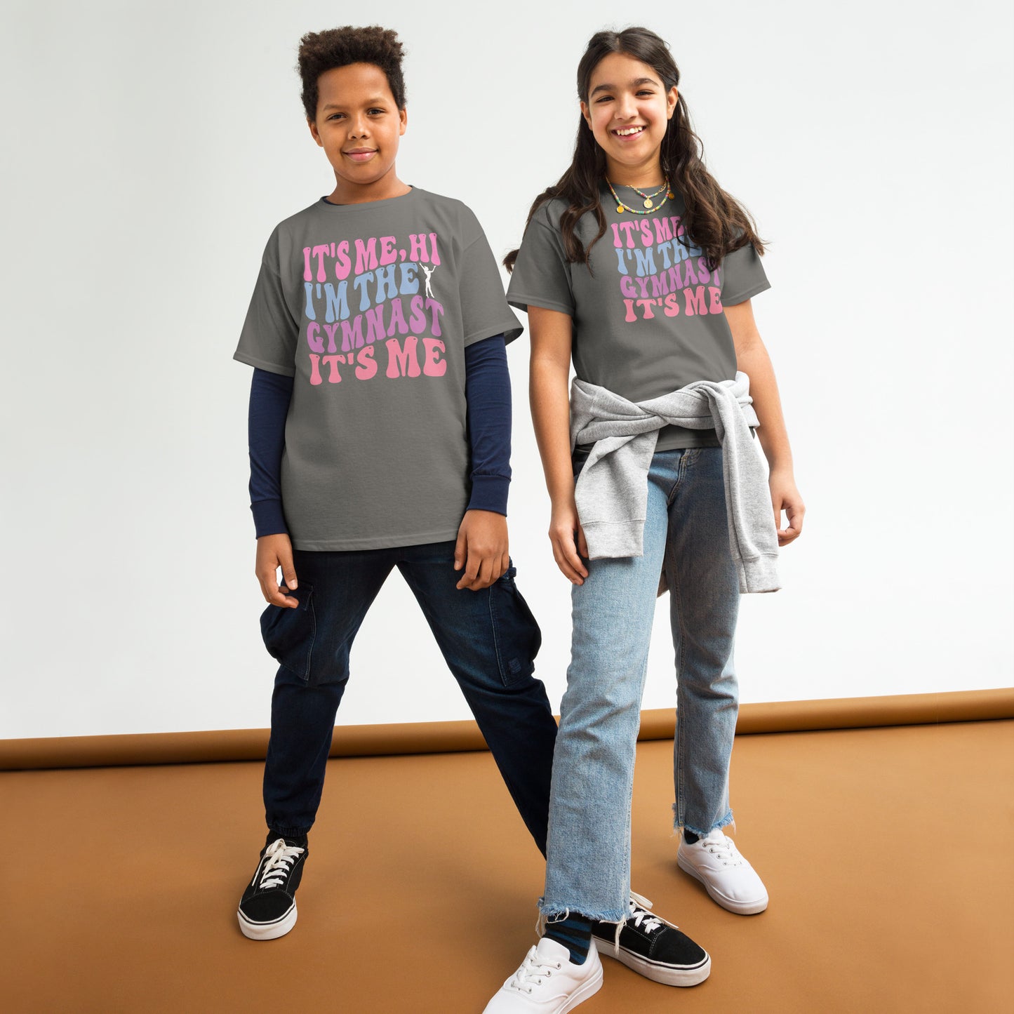 Kids gymnastics T-shirt, charcoal gray, with pink “It’s Me Hi…Gymnast” text graphic