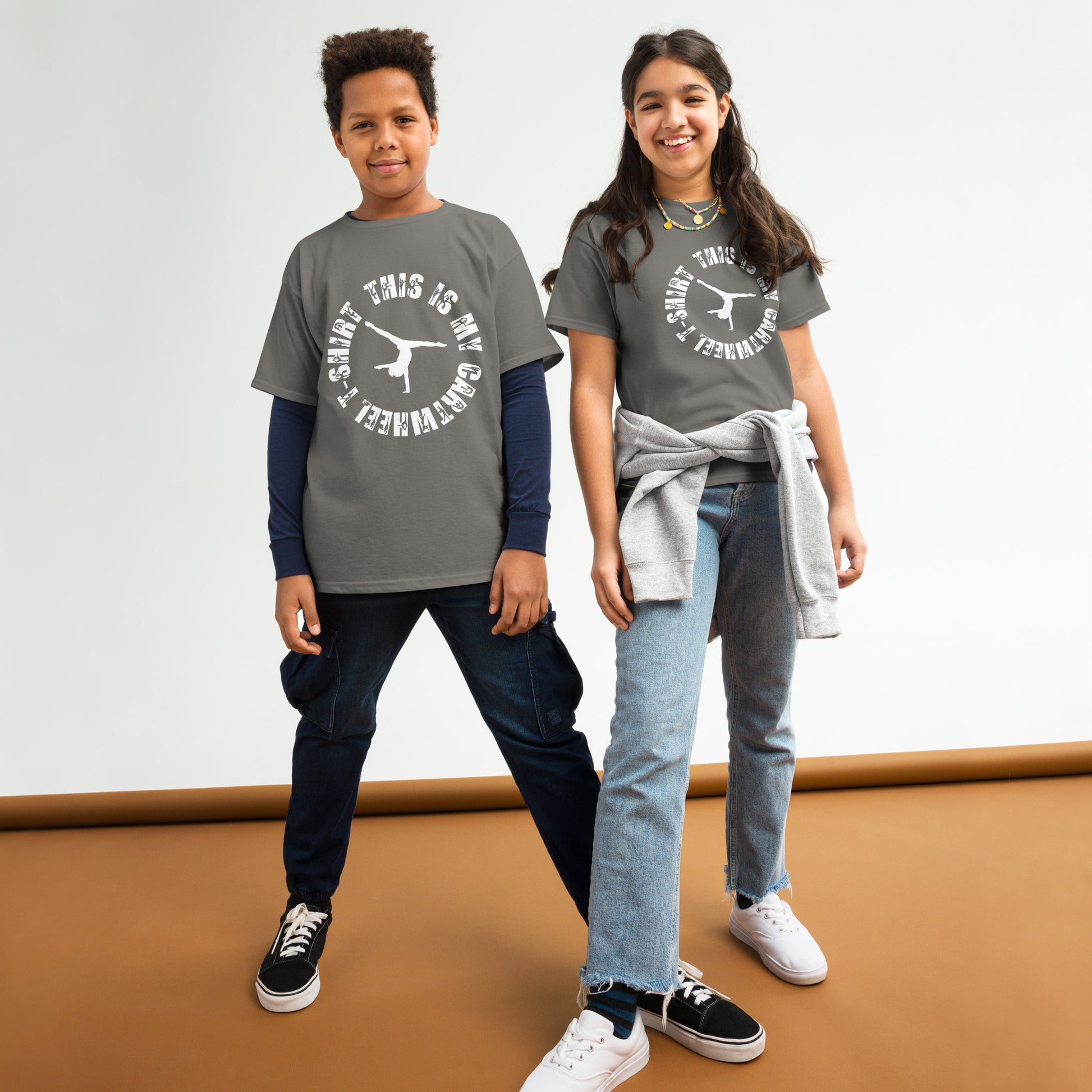 Kids gymnastics T-shirt outfit on two children; gray tee with white gymnast logo