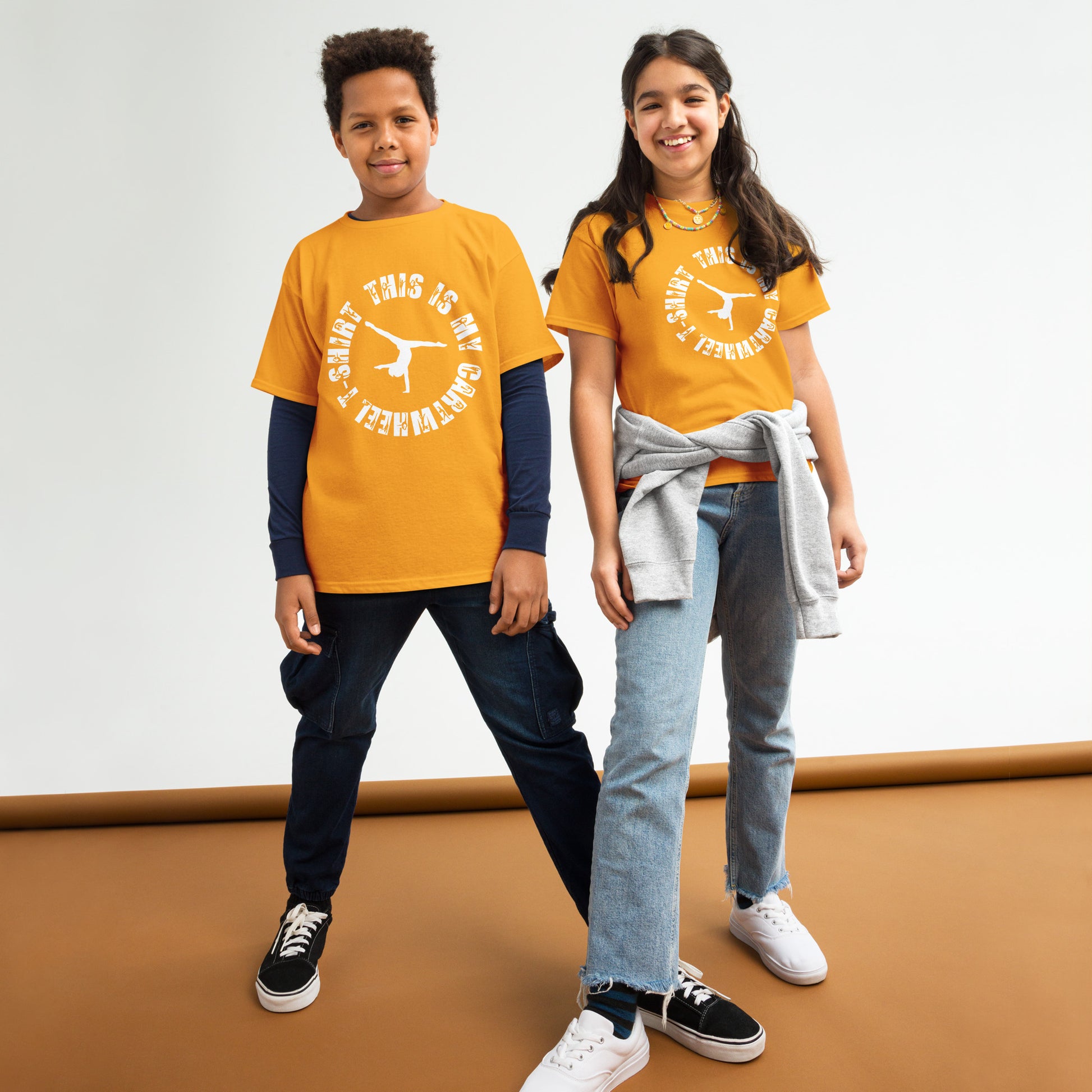 Kids gymnastics T-shirt outfit on two children; orange tee with white gymnast logo