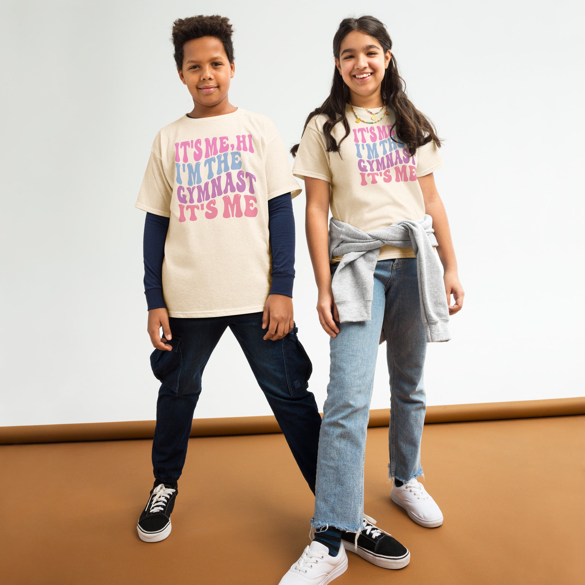 Kids gymnastics T-shirt, natural beige, with pink “It’s Me Hi…Gymnast” text graphic