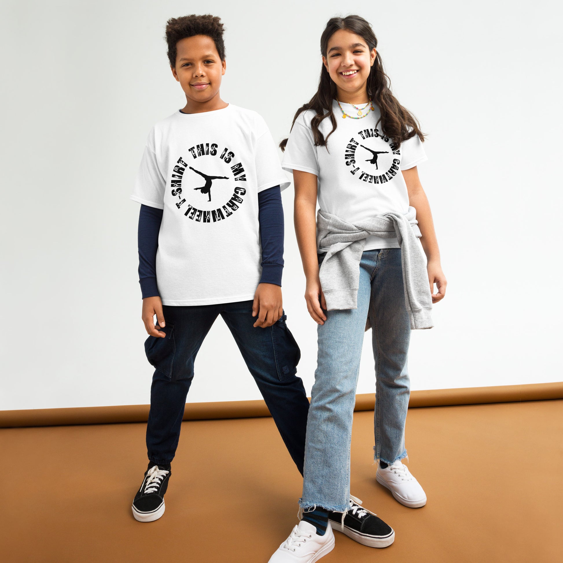 Kids gymnastics T-shirt in white with black gymnast graphic and ring text.